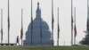 A visitor walks around the Washington monument as American flags are held at half staff in remembrance of the 20th anniversary of the September 11 attacks, on the National Mall near the U.S. Capitol in Washington, U.S., September 11, 2021. 