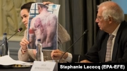 Светлана Тихановская показывает фотографии избитых в СИЗО людей во время неформального завтрака с министрами иностранных дел ЕС в Брюсселе, 21 сентября 2020 года 