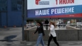 RUSSIA -- People walk past a billboard poster promoting the 2020 Russian constitutional referendum and reading "All-Russian voting; 1 July; Our Dicision" on a street in Novosibirsk, June 10, 2020
