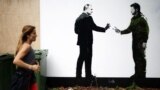 U.K. – A person jogs past a mural by street artist Loretto depicting Ukraine's President Volodymyr Zelenskiy (R) and Russian President Vladimir Putin, in London, Britain, October 4, 2022