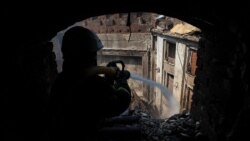 Пожарный тушит возгорание в харьковском доме культуры, пострадавшем от российского ракетного удара 18 августа 2022 года