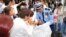 Japan -- A security person (C) gives directions witoth commuters near a railway station in Osaka on June 18, 2018. A strong quake hit western Japan early June 18, but there were no immediate reports of major damage or risk of tsunami waves, officials said