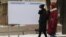 Kazakhstan. Election 2021. Women pass by an empty stand before the parlamentary elections. Almaty, December 13, 2020