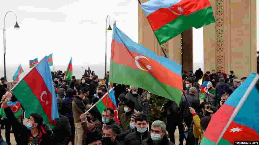 AZERBAIJAN -- People wave national flags as they celebrate the country's victory over Armenia after a weeks-long war over the disputed Nagorno-Karabakh region in Baku, November 20, 2020