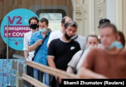 People line up outside a COVID-19 vaccination center in Moscow's State Department Store (GUM) on June 25, 2021.