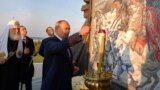 Путин зажигает свечу у мемориала Александру Невскому в Самолве 