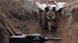 UKRAINE -- A Ukrainian serviceman walks in a trench as he stands at his post on the frontline with Russia backed separatists near the town of Zolote, in the Luhansk region, April 8, 2021
