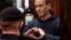 RUSSIA - This screen grab from a handout footage provided by the Moscow City Court press service shows Russian opposition leader Alexei Navalny, charged with violating the terms of a 2014 suspended sentence for embezzlement, gesturing a heart shape from i