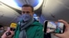 Russian opposition leader Aleksei Navalny boards a January 17, 2021 flight from Berlin to Moscow after completing medical treatment in Germany for a Novichok nerve-agent poisoning. 