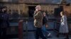 RUSSIA -- A Russian Federal Guard Service (FSO) officer, left, wearing a face mask to protect against coronavirus stands guard as tourists also wearing in face masks walks to visit the Mausoleum of the Soviet founder Vladimir Lenin on the usually crowded 
