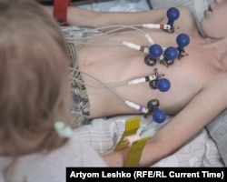 Doctors perform an EKG on a boy named Artyom.