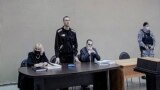Алексей Навальный (в центре) во время заседания суда в ИК-2 в городе Покров Владимирской области. Фото- и видеосъемку журналисты ведут через экран трансляции. 15 февраля 2022 года. Фото: EPA-EFE