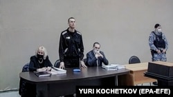 Алексей Навальный (в центре) во время заседания суда в ИК-2 в городе Покров Владимирской области. Фото- и видеосъемку журналисты ведут через экран трансляции. 15 февраля 2022 года. Фото: EPA-EFE