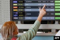 Женщина в аэропорту имени Бен Гуриона смотрит на расписание рейсов из Киева