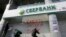 Ukraine -- Members of the National corp political party attach stickers during a protest outside the central branch of Sberbank in Kyiv,  March 10, 2017
