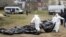 UKRAINE – Men wearing protective gear exhume the bodies of civilians killed during the Russian occupation in Bucha, on the outskirts of Kyiv, April 8, 2022
