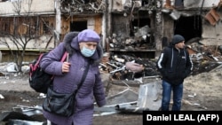 Женщина возле разрушенного дома в Киеве