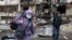 Женщина возле разрушенного дома в Киеве