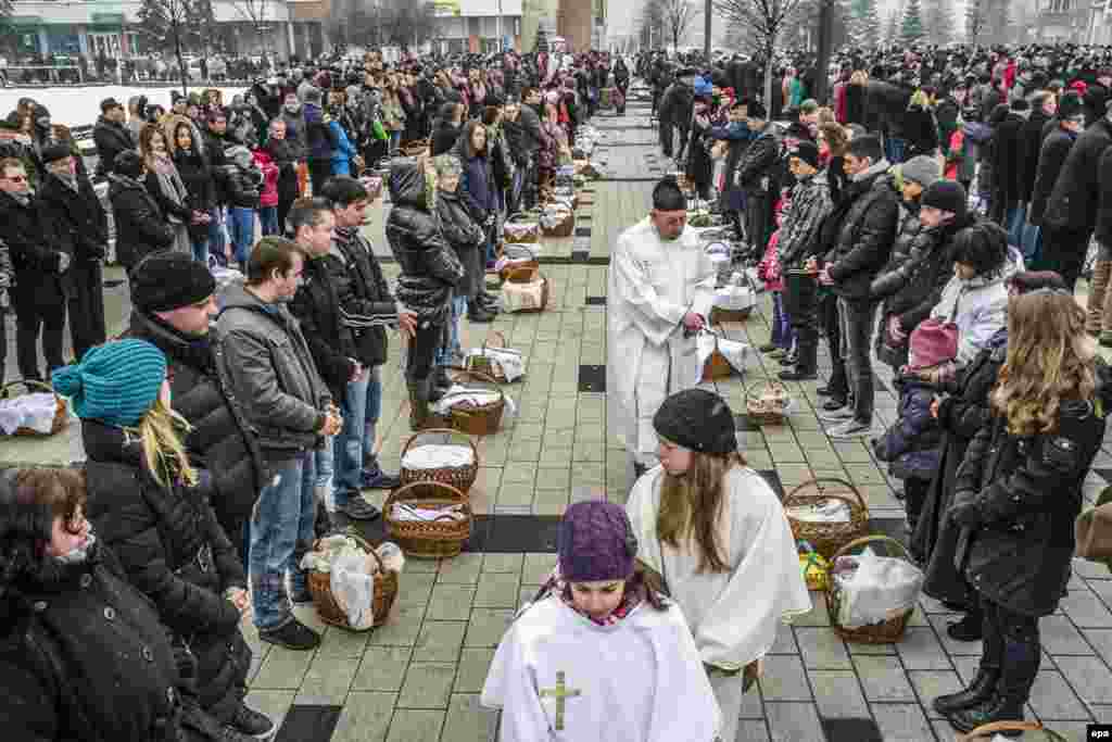 На фото &ndash; румынский католический священник благославляет корзины с едой на главной площади города Меркуря-Чук