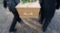 Generic -- Six peoply are carrying a coffin on to a cemetery