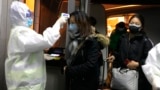 CHINA - Health Officials in hazmat suits check body temperatures of passengers arriving from the city of Wuhan, 22Jan, Wuhan 