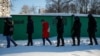 RUSSIA - Law enforcement officers walk behind people near a court building during a hearing to consider the case of Russian opposition leader Alexei Navalny, who is accused of flouting the terms of a suspended sentence for embezzlement, in Moscow, Russia 
