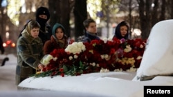 Люди в Москве возлагают цветы к Соловецкому камню в память об Алексее Навальном, 16 февраля 2024 года