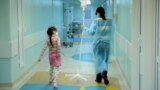 Russia -- A woman carries a dropper of her daughter, patient of the oncology unit, in the RDKB (a cyrillic acronym for Russian Children's Clinical Hospital) in Moscow, November 10, 2011 