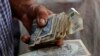 A farmer holds a wad of Cuban money