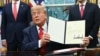 US President Donald Trump holds a letter addressed to Congolese President Felix Tshisekedi congratulating him on the peace agreement with Rwanda during a meeting with Democratic Republic of the Congo Foreign Minister Thérèse Kayikwamba Wagner (R) and Rwan