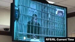 Pavel Ustinov appears on a video monitor during his hearing in a Moscow courtroom on September 20. 