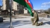 Azerbaijani President Ilham Aliyev kneels in front of the Azerbaijani flag during his visit to the Nagorno-Karabakh town of Shusha on January 15, 2021.