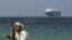 FILE PHOTO: Armed men stand on the beach as the Galaxy Leader commercial ship, seized by Yemen's Houthis last month, is anchored off the coast of al-Salif
