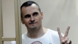 RUSSIA – Oleh Sentsov gestures as the verdict is delivered as he stands behind bars at a court in Rostov-on-Don, August 25, 2015