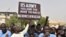 (FILES) Protesters react as a man holds up a sign demanding that soldiers from the United States Army leave Niger without negotiation during a demonstration in Niamey, on April 13, 2024.