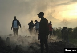 Жители на руинах разрушенных извержением вулкана домов в окрестностях Гомы, Демократическая Республика Конго. 23 мая 2021 года. Фото: Reuters