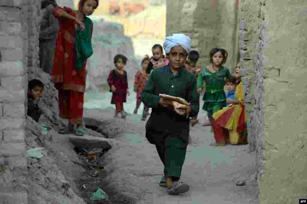 Утро праздника начинается с коллективной праздничной молитвы, люди приходят в мечети в самой нарядной одежде На фото - афганский мальчик несет хлеб для вечернего ифтара