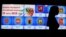 RUSSIA -- A woman walks past a screen announcing the forthcoming Russian presidential elections and displaying the coat of arms of Russia's regions at Russia's Central Election Commission headquarters in Moscow, March 7, 2018