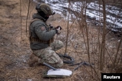 Украинский военнослужащий 47-й бригады готовит к работе систему спутникового интернета Starlink на своих позициях на линии фронта недалеко от города Авдеевка Донецкой области, 20 февраля 2024 года. Фото REUTERS
