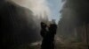 Пожарный пьет воду во время перерыва в разборе завалов поврежденного ракетным ударом здания в Славянске 29 августа 2022 года
