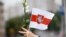 BELARUS – A protester holds a flag and flowers during an opposition demonstration against presidential election results in Minsk, August 22, 2020