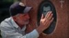 RUSSIA -- A man mourns at the cemetery, where victims of the 2004 school siege are buried, on the days of 17th anniversary of the siege, in the southern town of Beslan, September 1, 2021