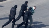 BELARUS -- Police officers detain a man at a planned rally after protesters were prevented from doing so by police, who cordoned off several streets, a main square and park in Minsk, March 27, 2021