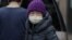 New York City, U.S. - A young resident of Chinatown wears a surgical mask 