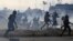 VENEZUELA --  Members of the Bolivarian National Guard loyal to Venezuelan President Nicolas Maduro run under a cloud of tear gas after being repelled with rifle fire by guards supporting Venezuelan opposition leader and self-proclaimed acting president J
