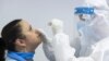 HUNGARY -- A medical student wearing protective clothing takes a swab sample for a COVID-19 rapid test in a school in Mandok, November 26, 2020