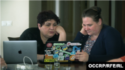 OCCRP journalist Miranda Patrucic (right) shows Khadija Ismayilova a leaked list of suspected Pegasus targets, which included Ismayilova.