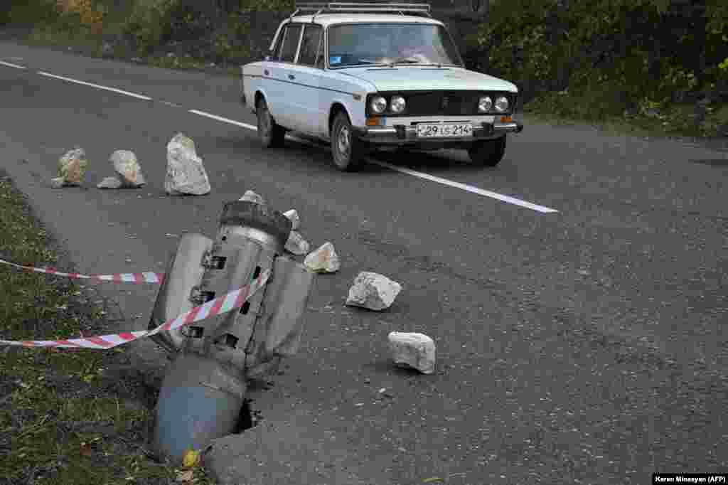 A car drives past the remains of a rocket shell near Shushi (Shusha) in late October 2020. Until 2017, the twisty, two-lane mountain road running from Karabakh&#39;s main town, Stepanakert, through Shushi was the only way for local residents to reach Armenia.&nbsp;