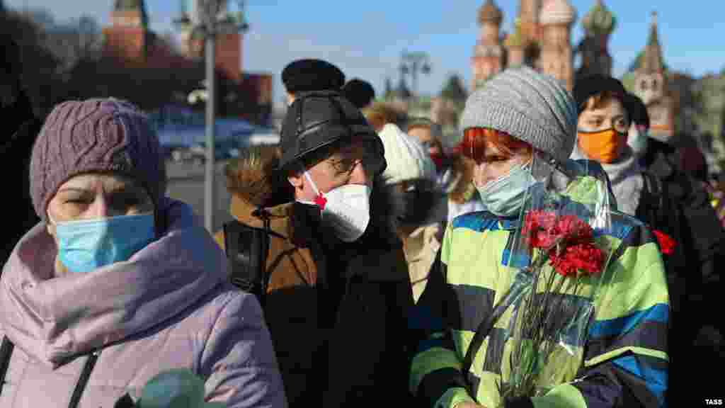 Люди приходили к мемориалу в течение всего дня 27 февраля. У основания моста волонтеры раздавали медицинские маски