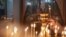 KYRGYZSTAN - A woman lights a candle in a church in Bishkek on January 7, 2019